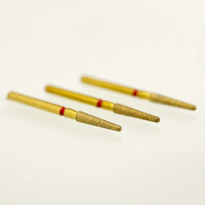 Three gold-colored cylindrical objects with red bands on a light beige background